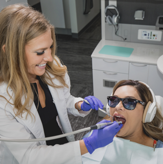 Dentist working with client in chair in Toothbar