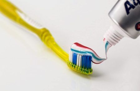 white and blue toothbrush with toothpaste