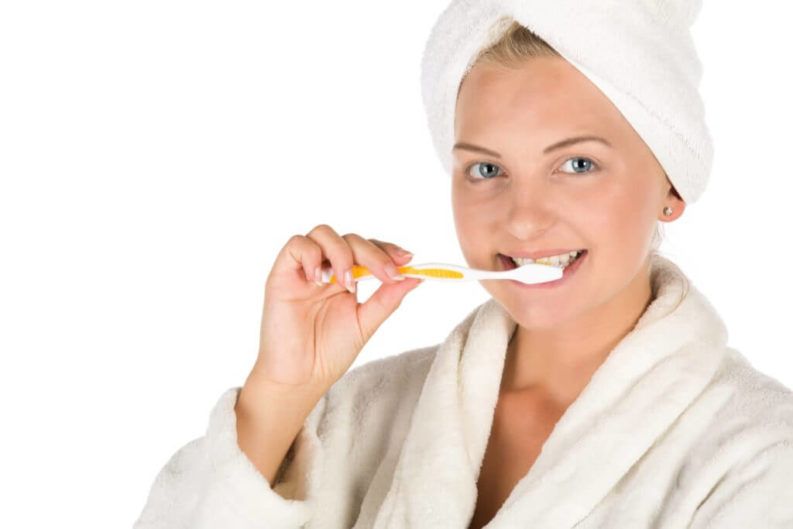 young woman brushing her teeth