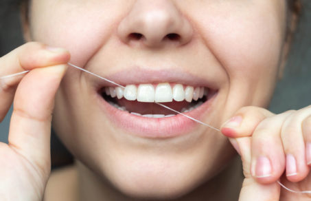 Woman using flossing her teeth for preventing Tooth Decay
