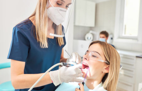 dentist performing a dental cleaning on patient