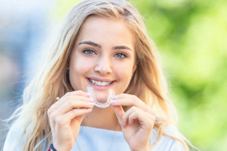 Austin Woman holding her invisalign aligners