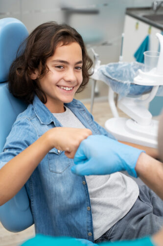happy kid at the dentist doing thumbs up